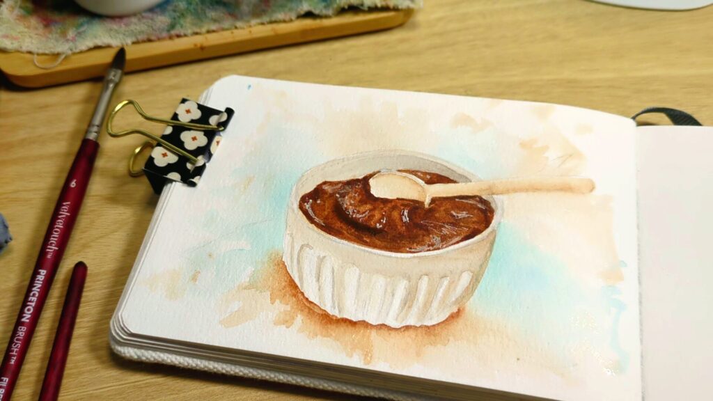 a watercolor painting of a bowl of chocolate frosting